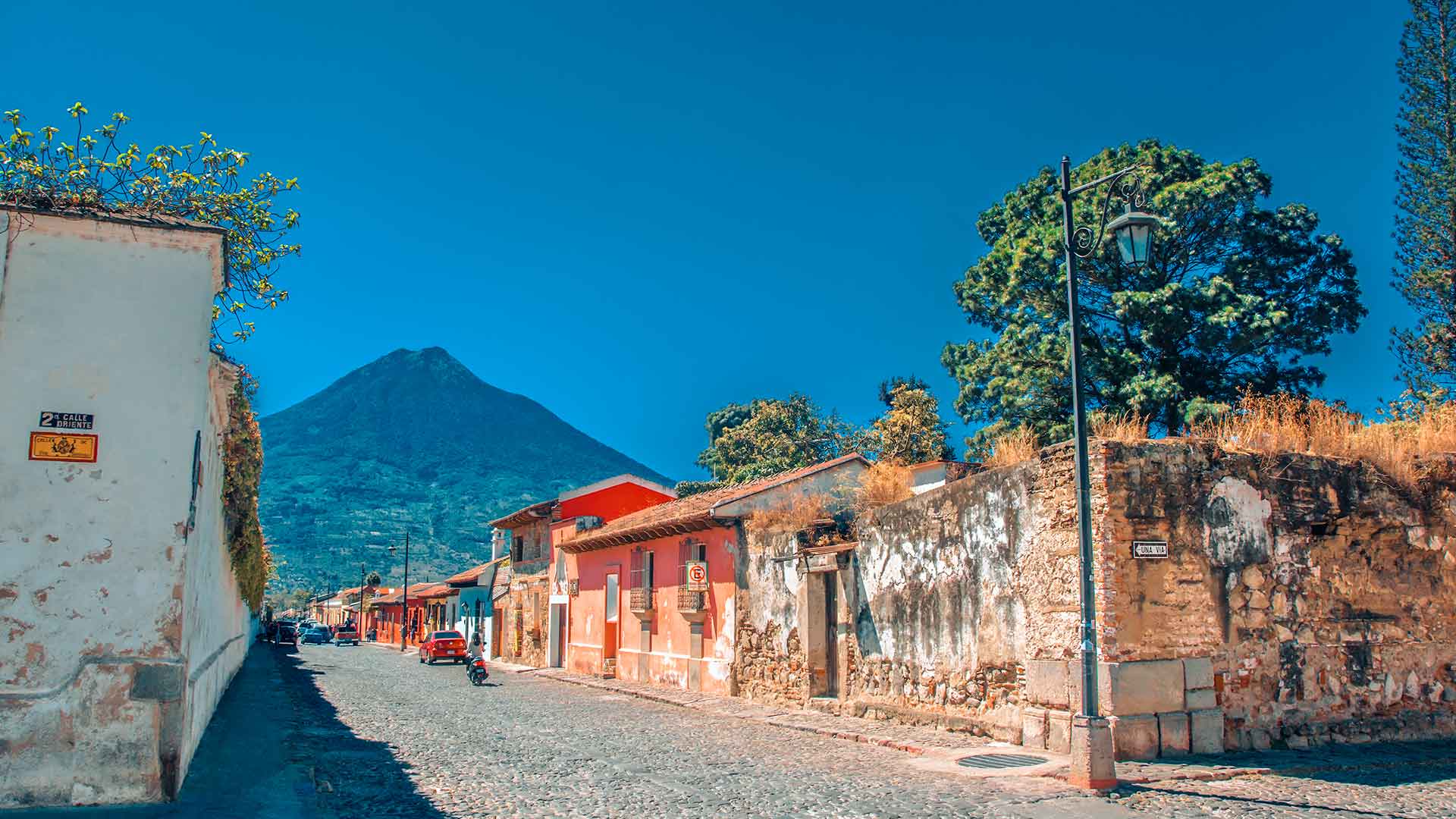 A picturesque street in Antigua Guatemala with the Agua volcano in the background. Is it safe to travel to Guatemala? Discover the safety and beauty of this destination.