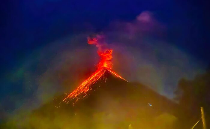 Acatenango Volcano Tour - Nocturnal view of Fuego Volcano erupting, seen from Acatenango Volcano, showcasing spectacular bursts of radiant magma, during the Volcano Hiking Trail in Guatemala.