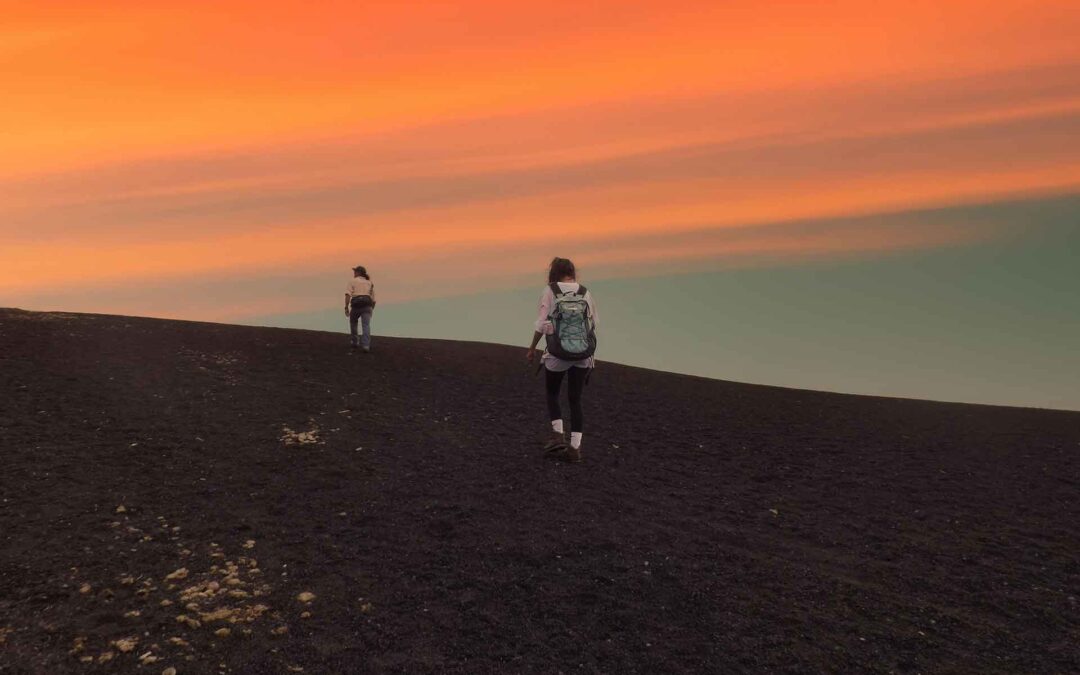 Adventurers reaching the peak of Pacaya volcano during the sunset as a part of the Guatemala Hiking Trails