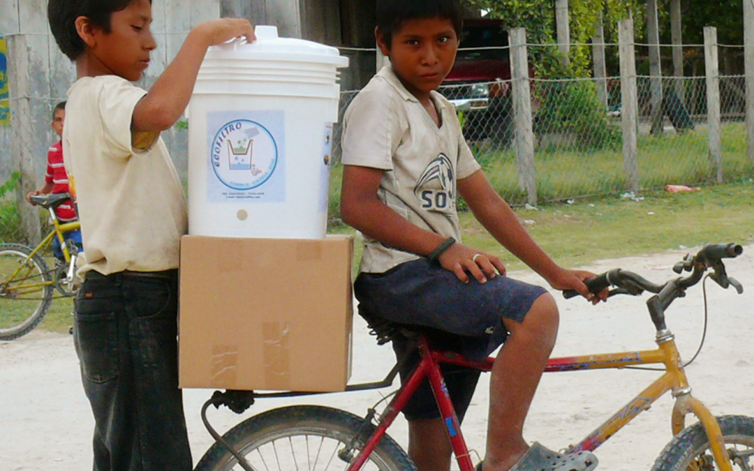 Two young men transport the Ecolfilter on their bicycle as part of the Pure Water Pathways Program, a sustainable initiative by Martsam Travel.